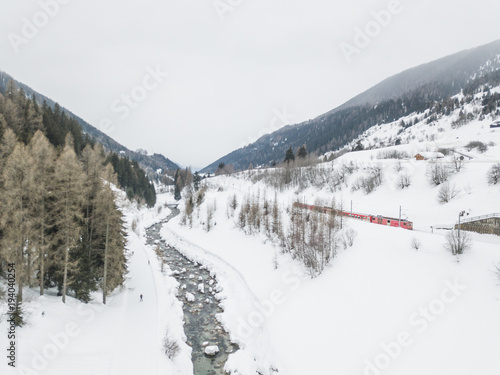 Aerial view of river in snow covered landscape in swiss mountains