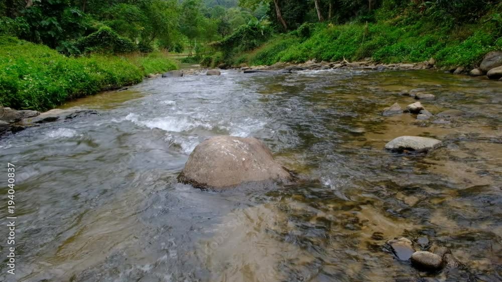 Pure fresh water flowing in forest with brown rocks and green jungle. Pure fresh water flowing in forest with brown rocks and green jungle.