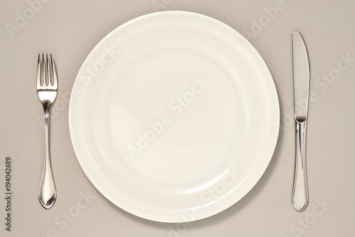 Empty Plate  Knife and Fork isolated on Grey Background with Real Shadow. Top View