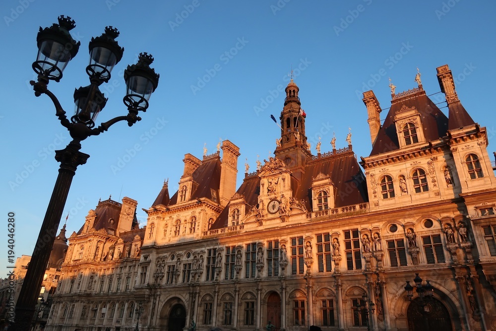 Façade de l’Hôtel de ville de Paris au soleil couchant avec un réverbère (France)