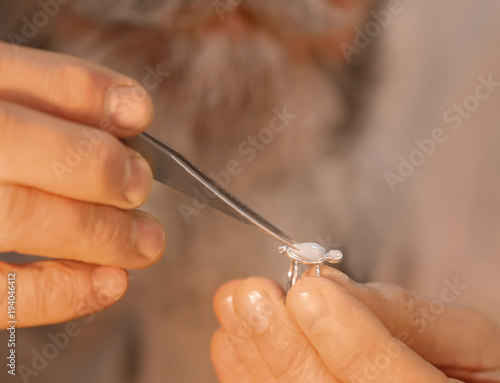 Jeweler repairing ring with gem, closeup