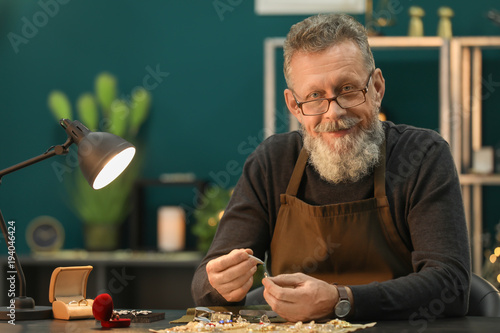 Canvas Print Senior jeweler in workshop at night