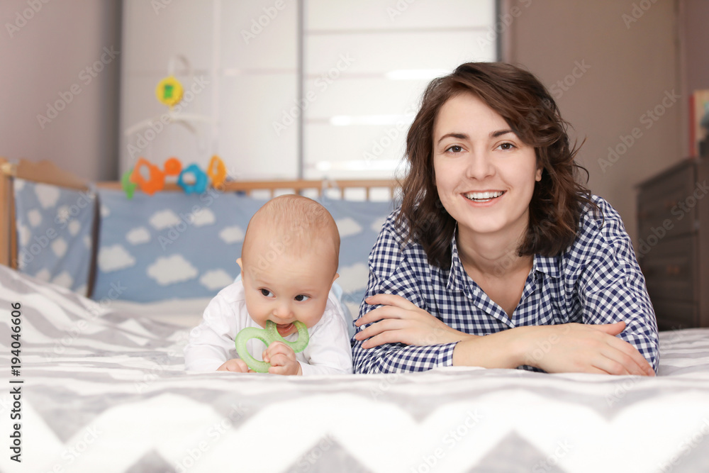 Young mother and her baby lying on bed at home Young mother and her baby lying on bed at home