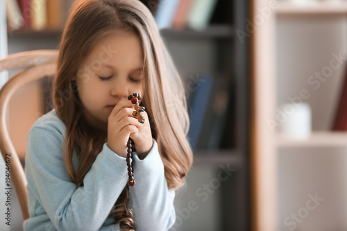 Religious Christian girl praying indoors