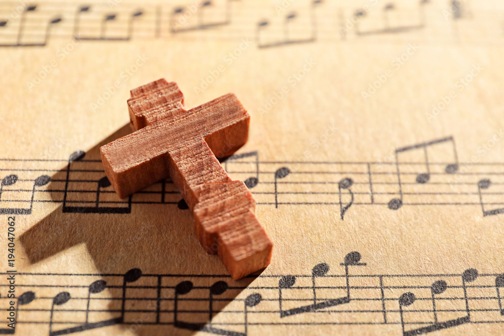 Fototapeta premium Wooden cross on music sheet