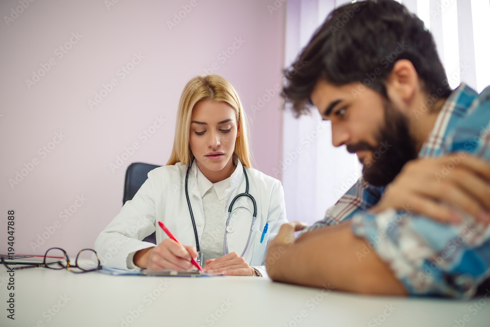 Fototapeta premium Female counselor writing down some information about her patient.