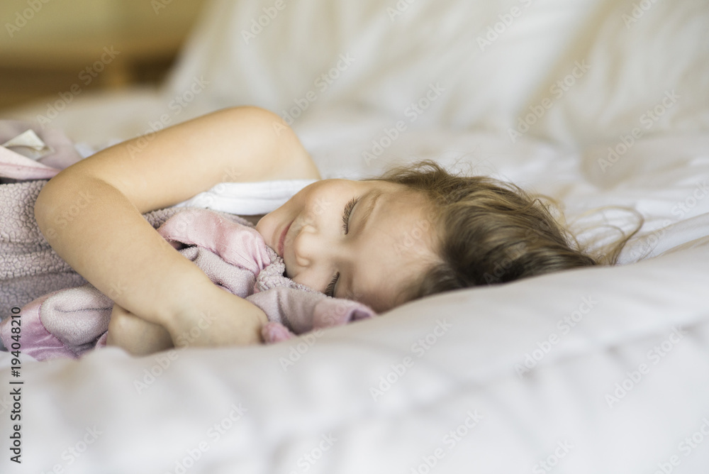 Smiling girl sleeping on bed at home Smiling girl sleeping on bed at home