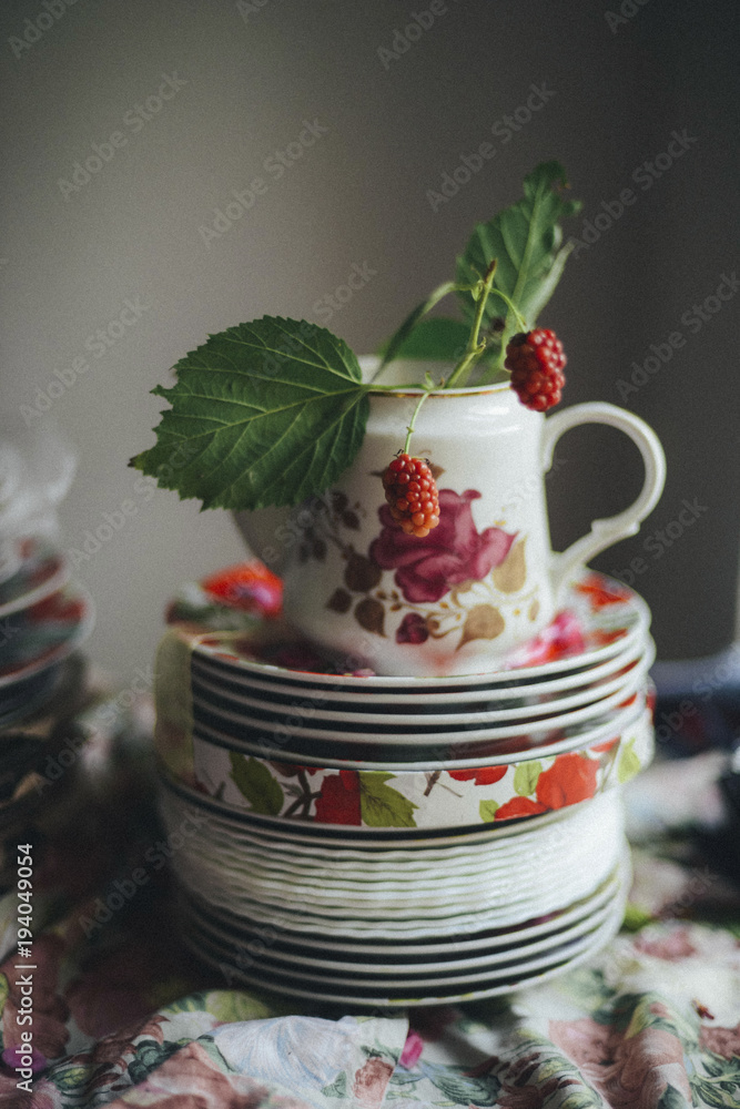 Close-up of fresh raspberries in teapot on stacked saucers Close-up of fresh raspberries in teapot on stacked saucers