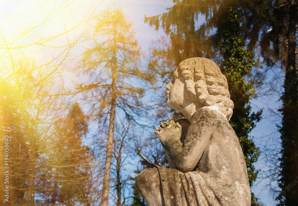 Olld stone angel in prayer to heaven (religion, baby angel, faith concept) Olld stone angel in prayer to heaven (religion, baby angel, faith concept)
