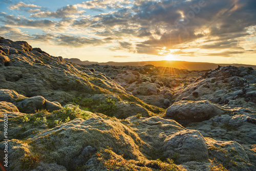 Scenic view of landscape against cloudy sky during sunrise