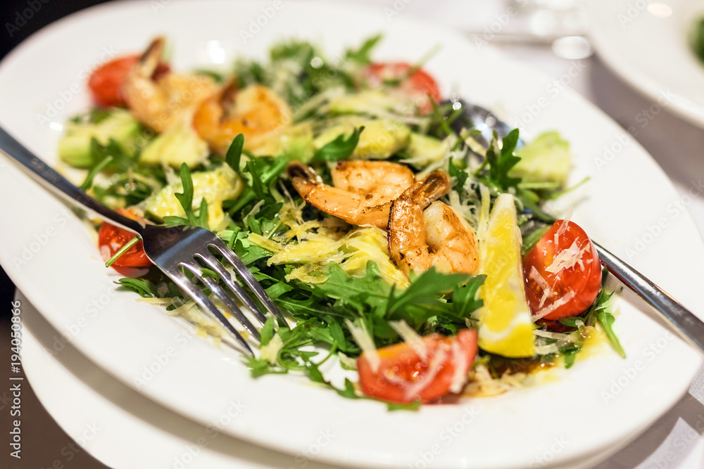 Plate with mixed shrimps salat. Dish with  prawns , arugula, tomato and cheese.  Delicious healthy meal
