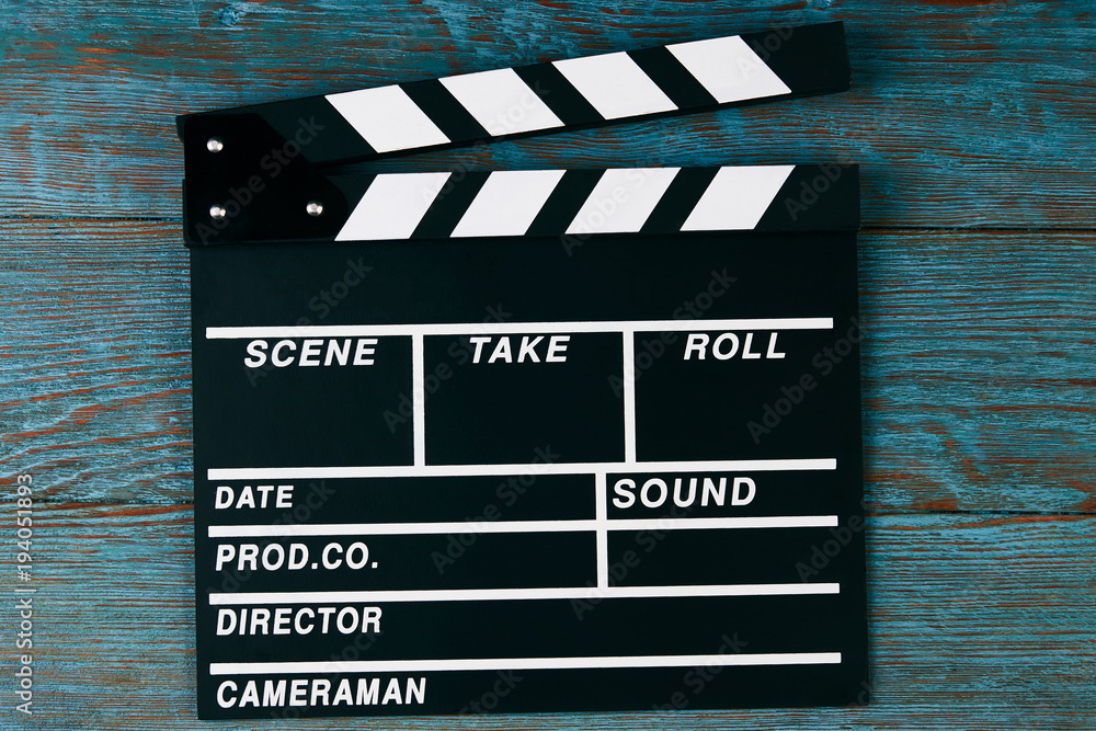 Obraz premium Movie clapper board. Black clapperboard on blue wooden background with copy space, close-up. Cinema and movie time concept