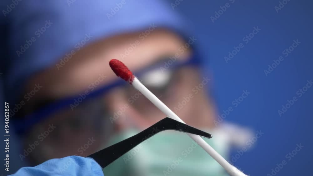 Doctor or investigator analyzing a swab soaked in blood. CSI Crime scene investigation concept. Doctor or investigator analyzing a swab soaked in blood. CSI Crime scene investigation concept.