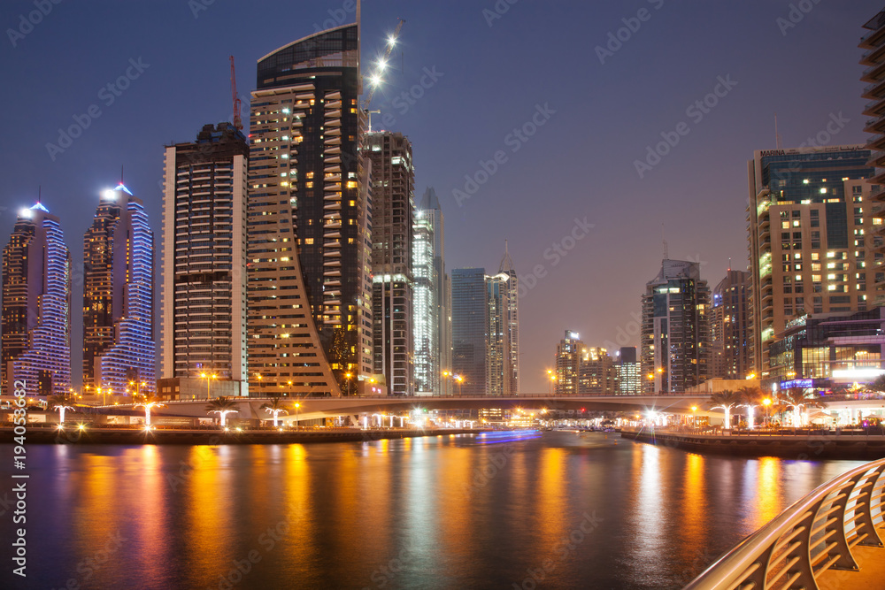Naklejka premium Dubaj, Zjednoczone Emiraty Arabskie - luty 2018: Kolorowy wieczór nad kanałem i promenadą w Dubai Marina, Dubaj, Zjednoczone Emiraty Arabskie