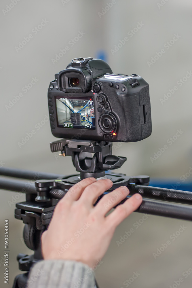 Videographer using camera slider, making video of business at factory Videographer using camera slider, making video of business at factory