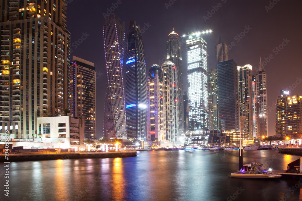 DUBAI, UAE - FEBRUARY 2018: Colorful evening on canal and promenade in Dubai Marina,Dubai,United Arab Emirates DUBAI, UAE - FEBRUARY 2018: Colorful evening on canal and promenade in Dubai Marina,Dubai,United Arab Emirates