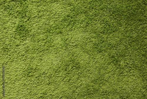 Green carpet. Surface imitating green grass. A close-up photograph. Top view 