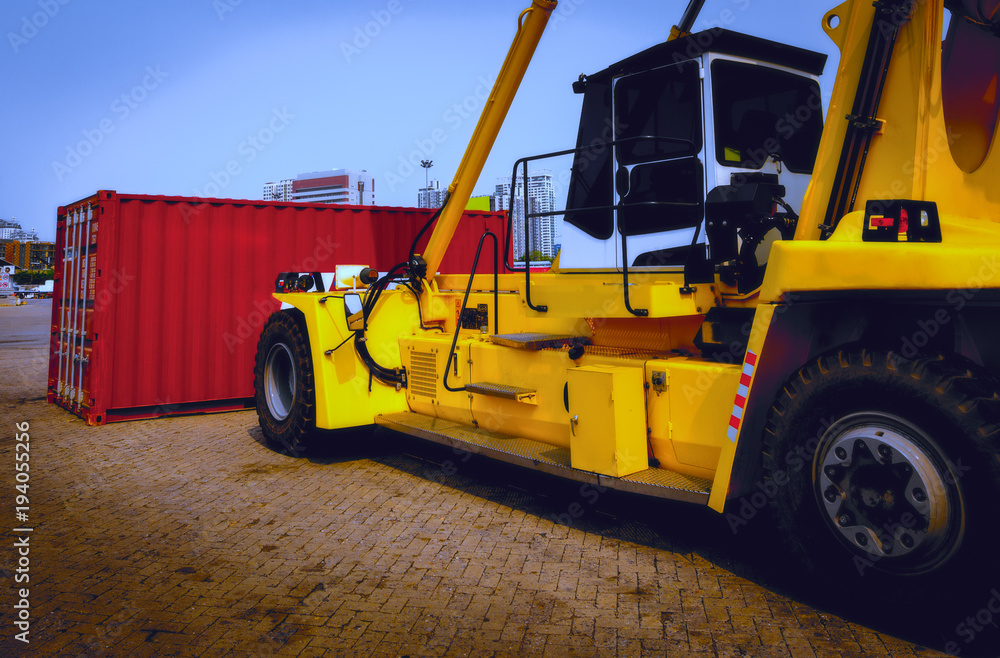 Yellow crane lifting with red container on a ground under blue sky background. Yellow crane lifting with red container on a ground under blue sky background.