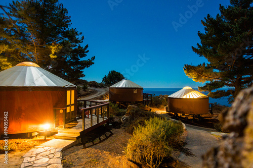 Yurts/tents under starlit sky in the woods, Big Sur, California photo