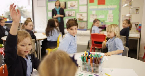 4K Primary school teacher talking to class of young children & asking questions. Slow motion