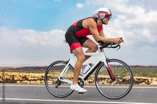 Triathlon cyclist man cycling racing on road bike on ironman competition racing against time. Triathlete training bicycle workout for triathlon race. © Maridav