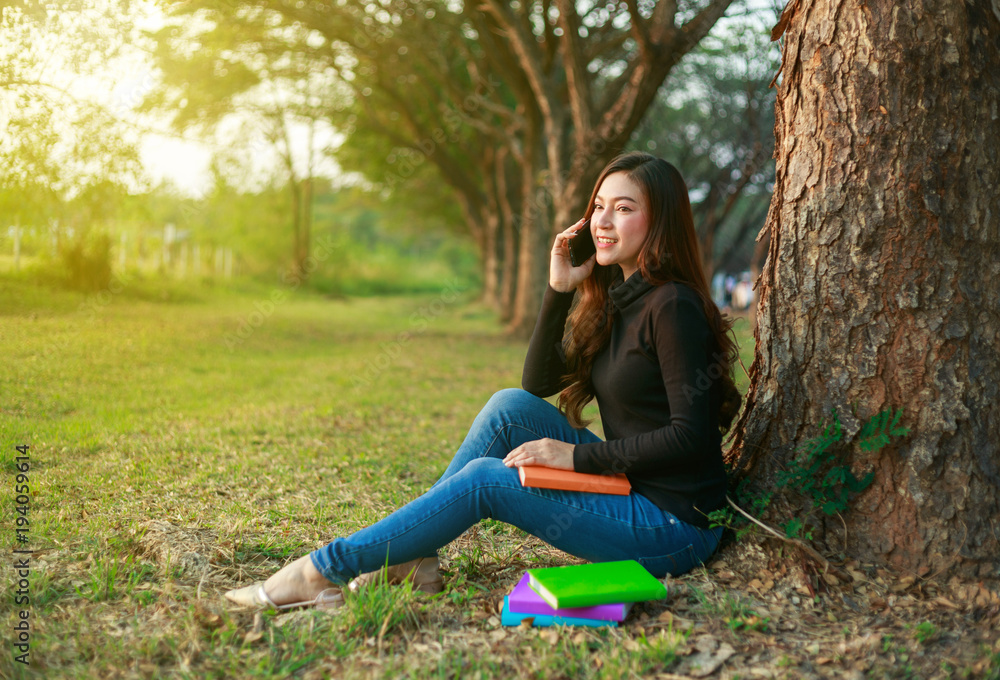 smiling woman talking on mobile phone in park smiling woman talking on mobile phone in park