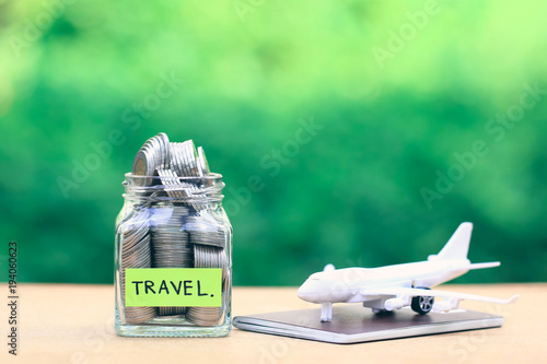 Saving planning for Travel budget of holiday concept,Financial,Stack of coins money in the glass bottle and airplane on passport with natural green background photo