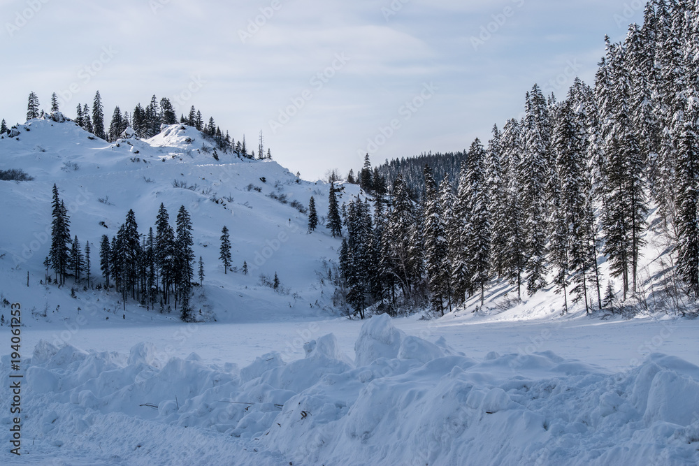 Winter landscape in the mountains with blue sky and snow-capped peaks and forest Winter landscape in the mountains with blue sky and snow-capped peaks and forest