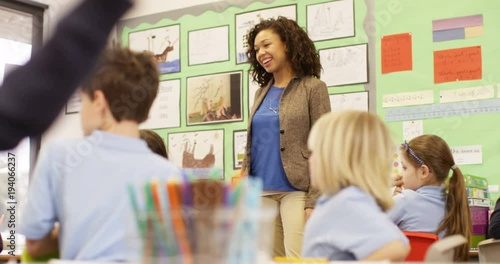 4K Elementary school teacher talking to class of young children & asking questions. Slow motion