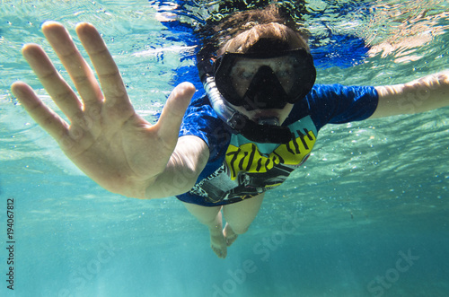 Teenager in a mask and a tube under the water
