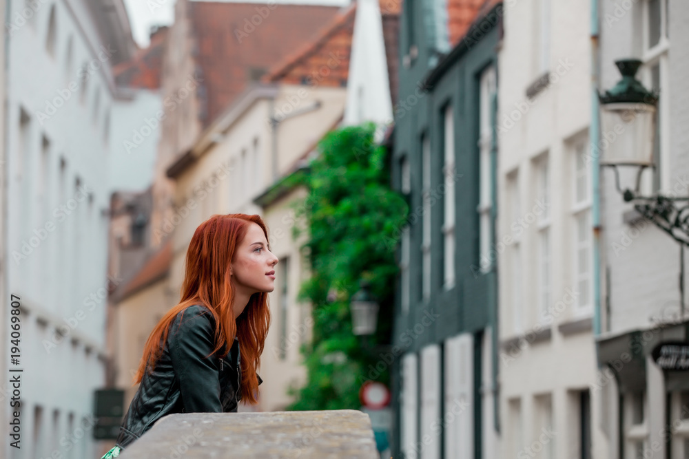 Fototapeta premium Young redhead girl rest on the street in Brugge