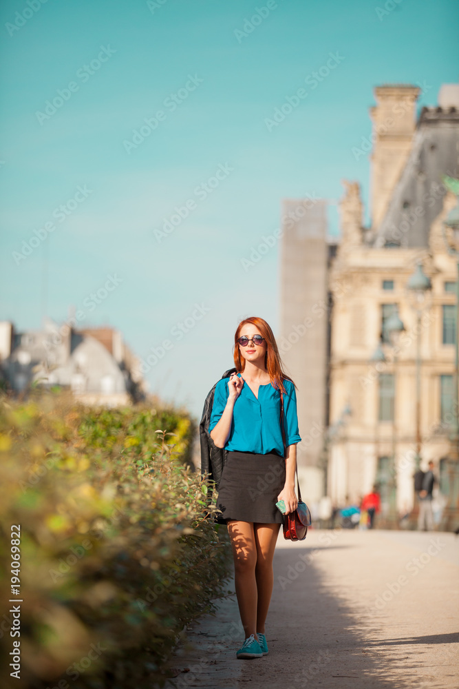 Young redhead woman in sunglasses walking on Parisian streets Young redhead woman in sunglasses walking on Parisian streets