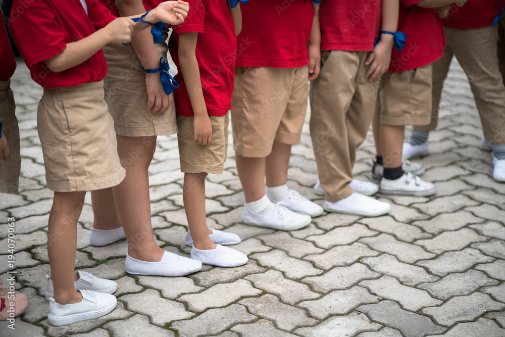 Uniformed children aligned legs standing on school playground
