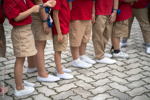 Uniformed children aligned legs standing on school playground © Hanoi Photography