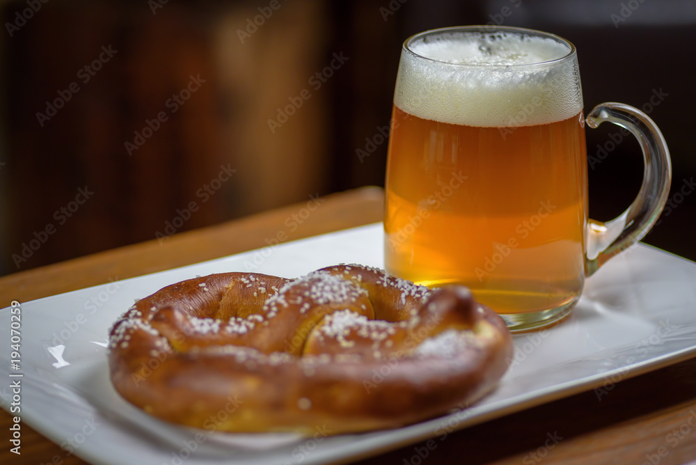 closeup of a large glass mug of beer and a soft pretzel closeup of a large glass mug of beer and a soft pretzel