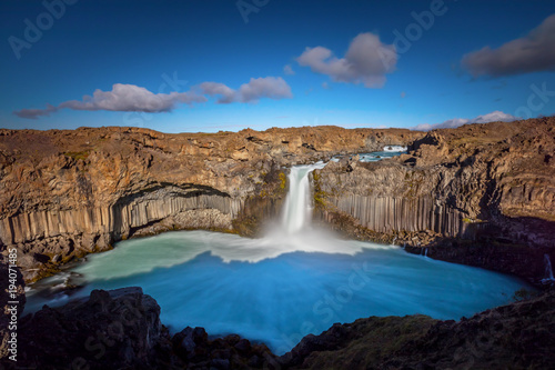 Aldeyjarfoss  Iceland with a powerful waterfall and the brilliant blue glacier water pool before flowing through a dramatic basalt canyon