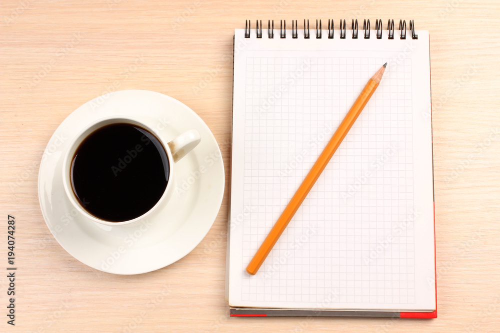 Cup of coffee and a notebook on the table Cup of coffee and a notebook on the table