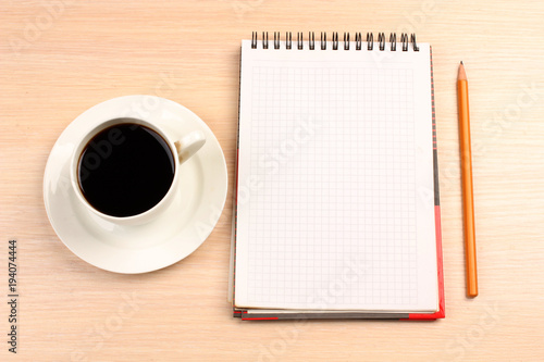 Cup of coffee and a notebook on the table