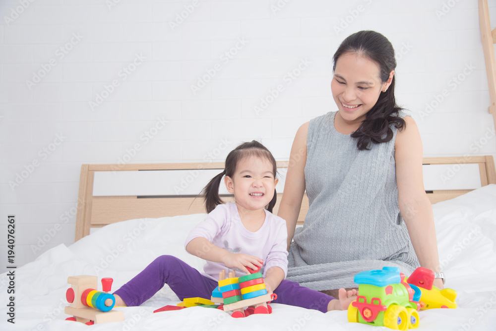 Little asian girl playing toy with her mother Little asian girl playing toy with her mother