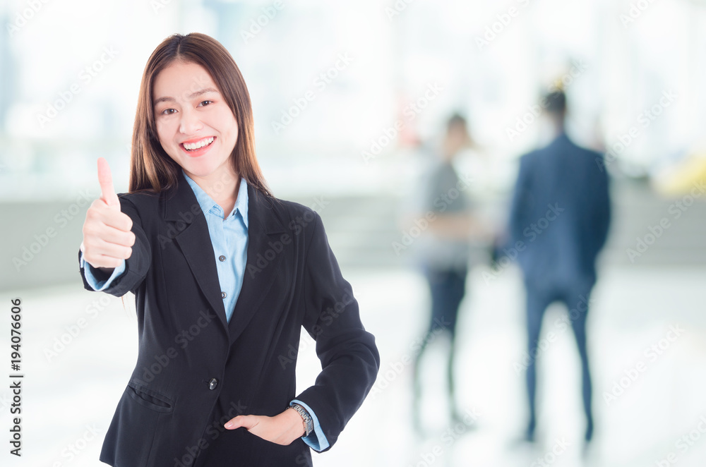 Beautiful young asian businesswoman smiling and showing thumb up in office Beautiful young asian businesswoman smiling and showing thumb up in office