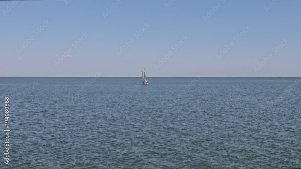 A sailing ship is in the calm waves of the ocean in calm weather A sailing ship is in the calm waves of the ocean in calm weather