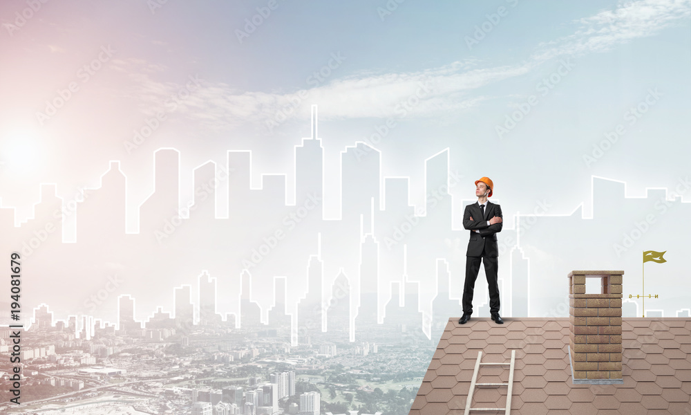 Engineer man standing on roof and looking away. Mixed media Engineer man standing on roof and looking away. Mixed media
