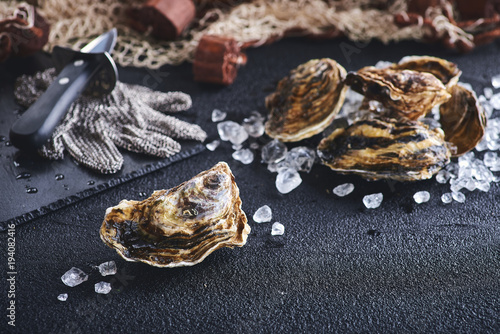 Fresh oyster on ice on a black stone table