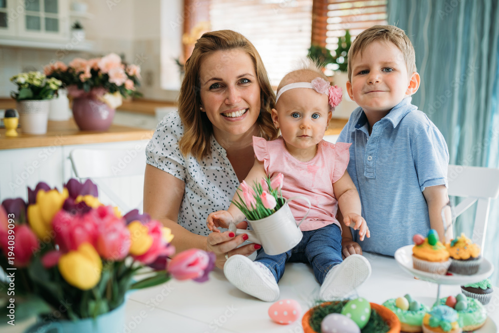 Fototapeta premium Happy easter. A mother and her kids painting Easter eggs