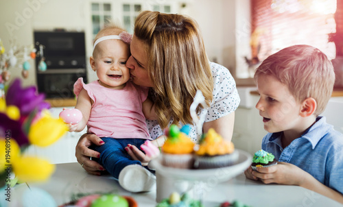 Happy easter. A mother and her kids painting Easter eggs