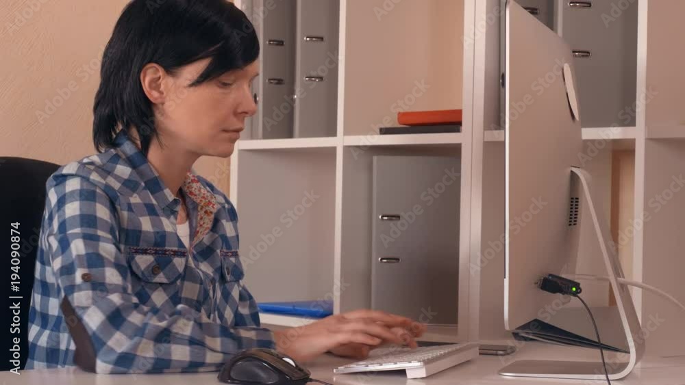 casual employee in startup company sitting at the working place using computer. focused businesswoman looking on display pc entering data. work day in creative office casual employee in startup company sitting at the working place using computer. focused businesswoman looking on display pc entering data. work day in creative office