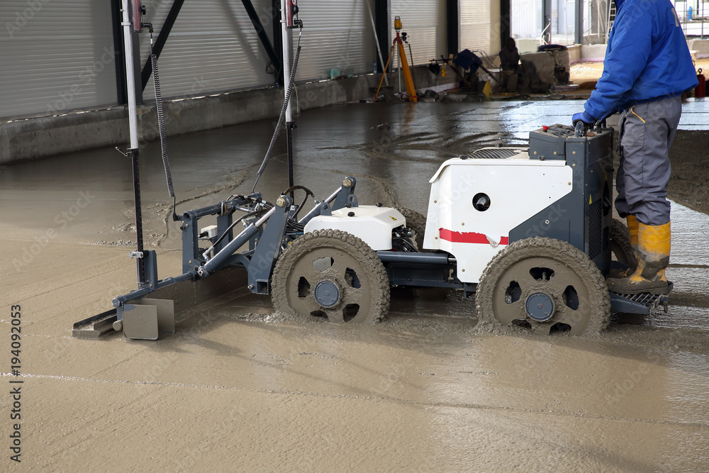 Laser screed machine leveling fresh poured concrete surface on a  construction site Stock Photo | Adobe Stock