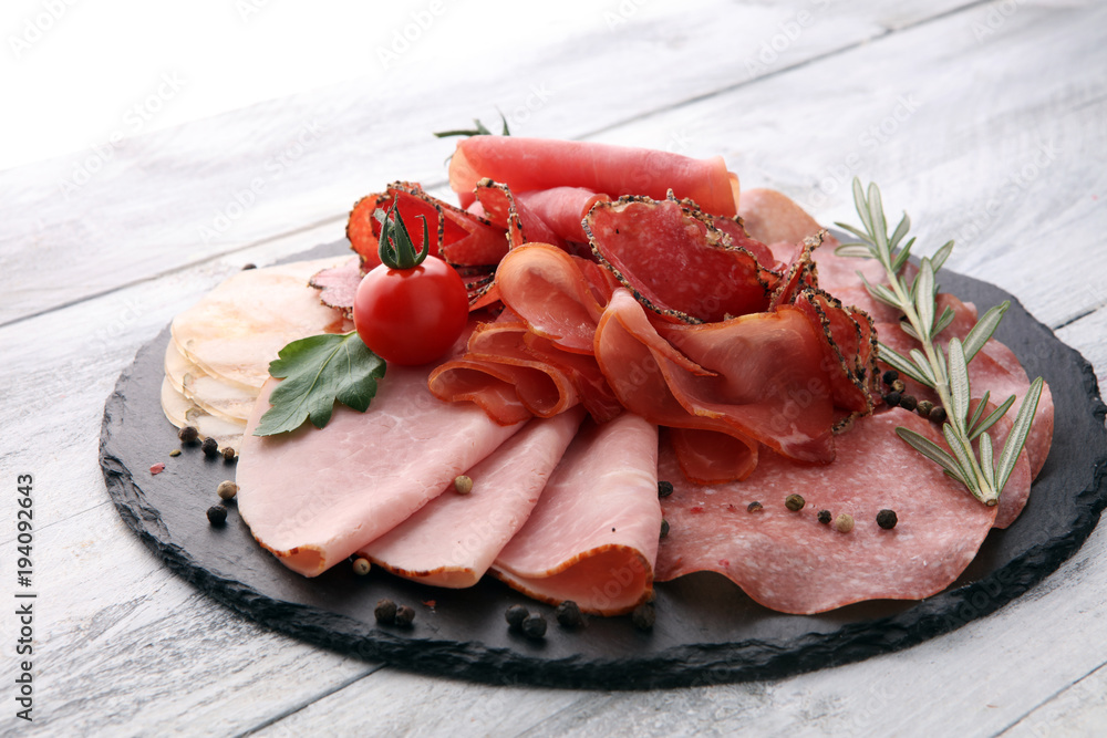 Food tray with delicious salami, pieces of sliced ham, sausage, tomatoes, salad and vegetable - Meat platter with selection Food tray with delicious salami, pieces of sliced ham, sausage, tomatoes, salad and vegetable - Meat platter with selection