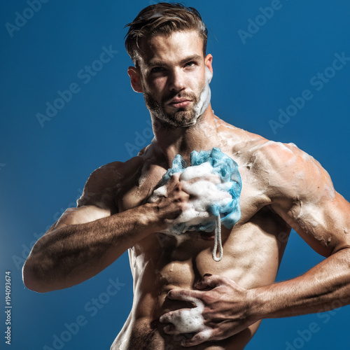 Spa and beauty, relax and hygiene, healthcare - handsome man washing with sponge in shower. Athletic, handsome guy muscular body soaping himself in shower. Man receives relaxing shower after hard day.