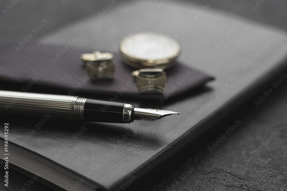 Black style Man set: notepad, pen and cufflinks. Black background Black style Man set: notepad, pen and cufflinks. Black background
